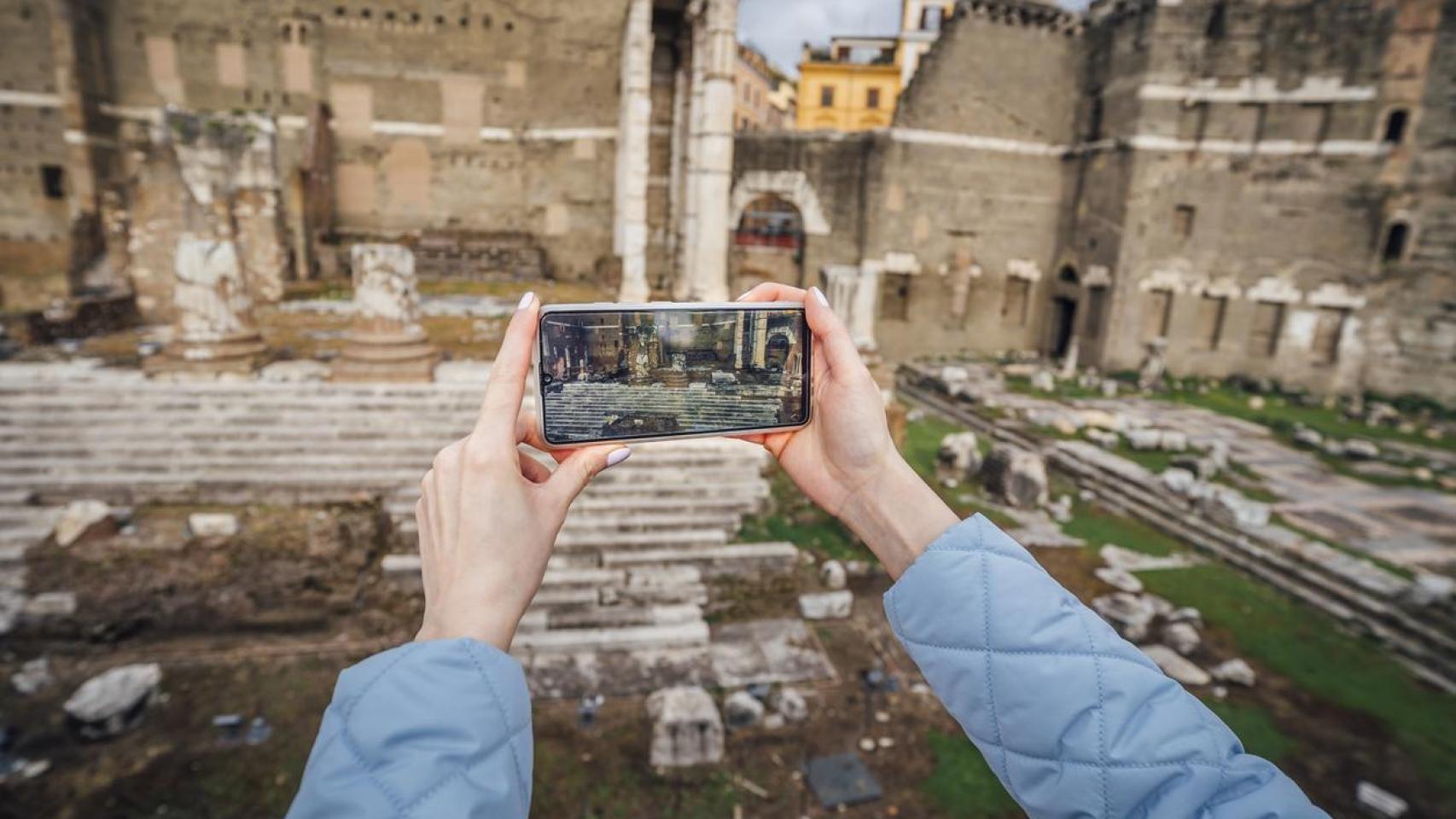 Persona sacando foto a un monumento romano.