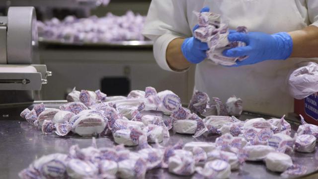 Una operaria manipula polvorones de almendra en una fábrica de mantecados en Estepa.