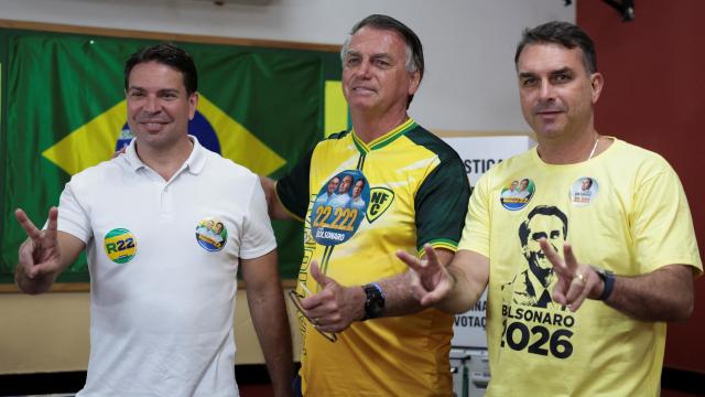 Jair Bolsonaro posa con  Alexandre Ramagem y su hijo Flavio, después de votar en  Río de Janeiro.