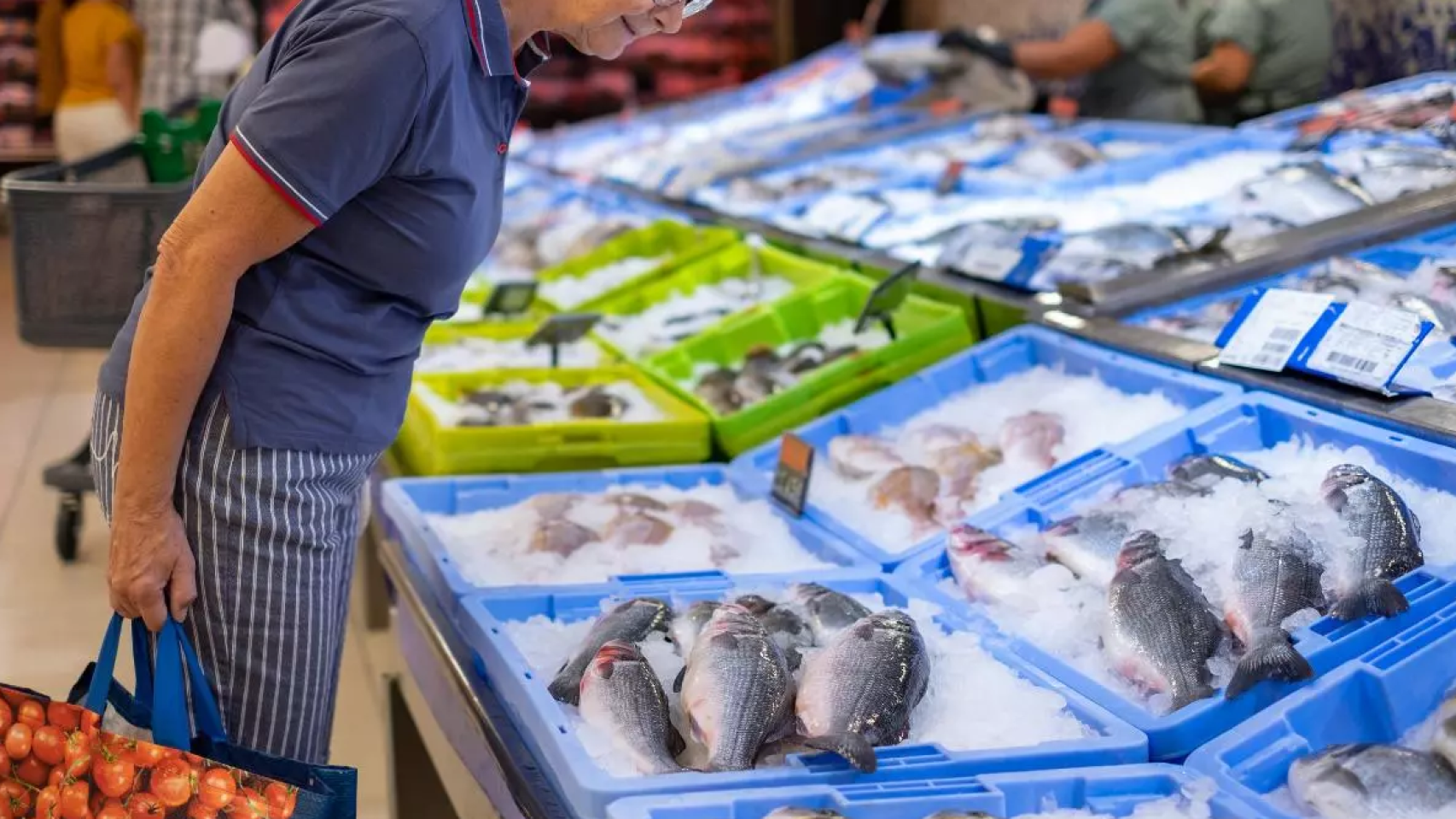 Una mujer consultado el producto de una pescadería de Mercadona.