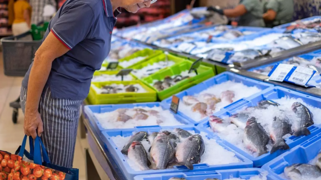 Una mujer consultado el producto de una pescadería de Mercadona.