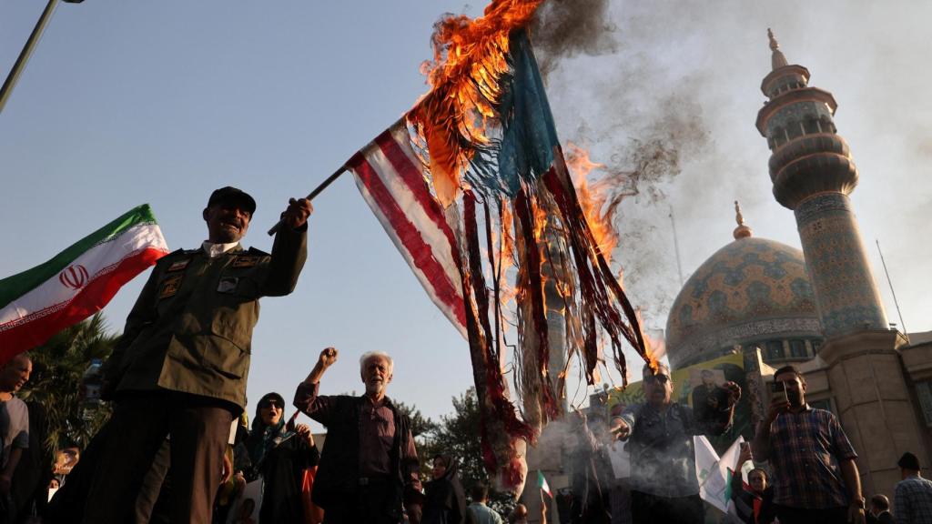 Manifestantes iraníes queman banderas israelíes y estadounidenses en una protesta en Teherán.