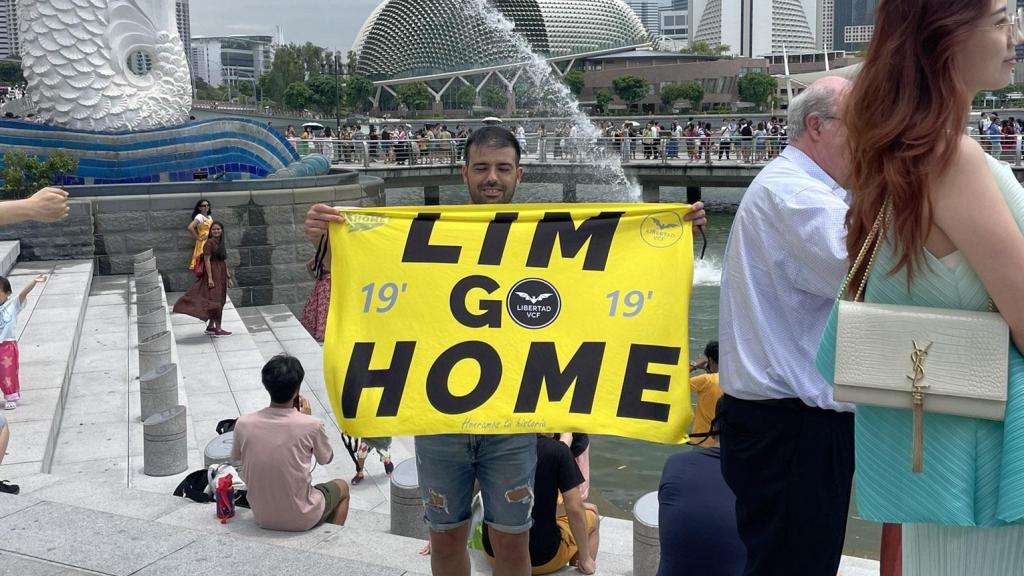 Dani Cuesta en Singapur con el cartel contra Peter Lim. X