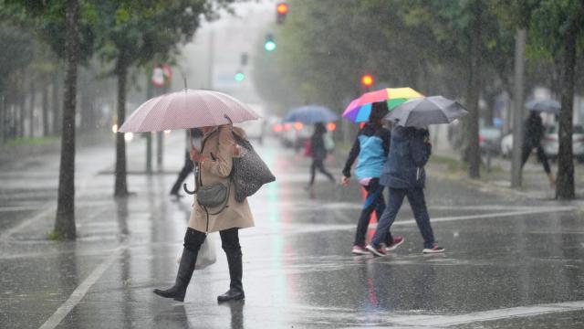 Imagen de archivo de personas caminando bajo la lluvia.