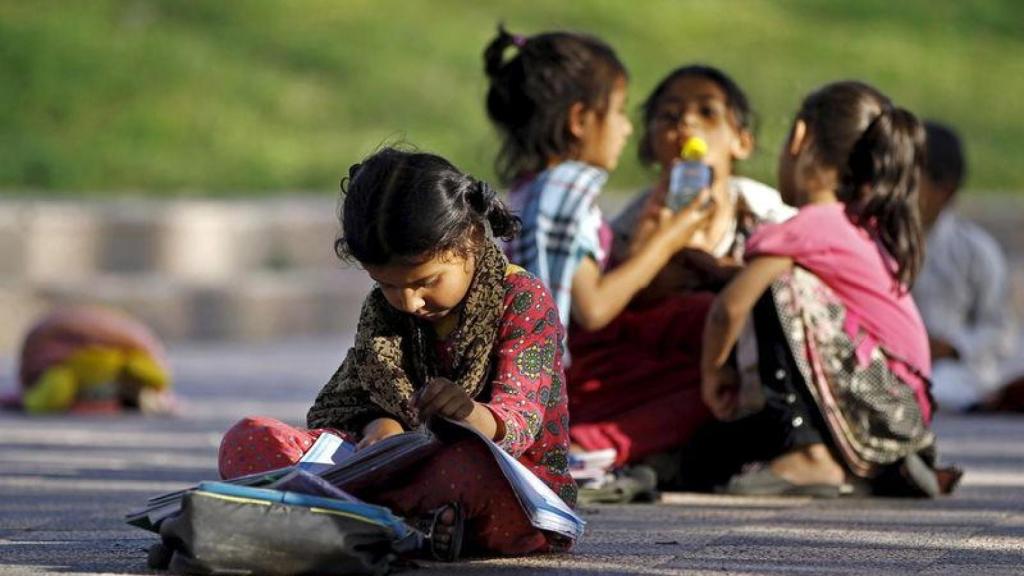 Niñas sin recursos leyendo sentadas en el suelo.