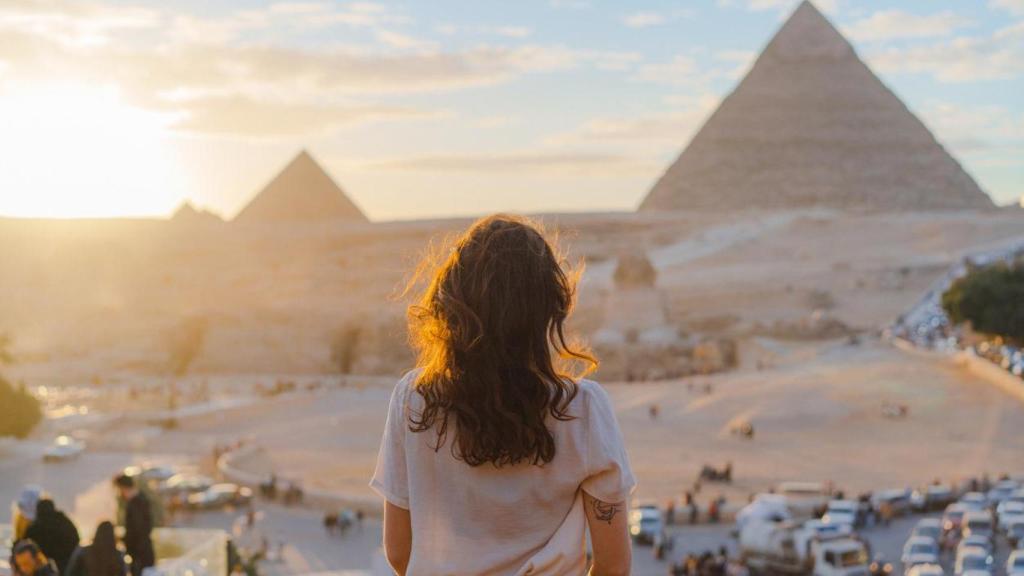 Mujer mirando las pirámides de Egipto.