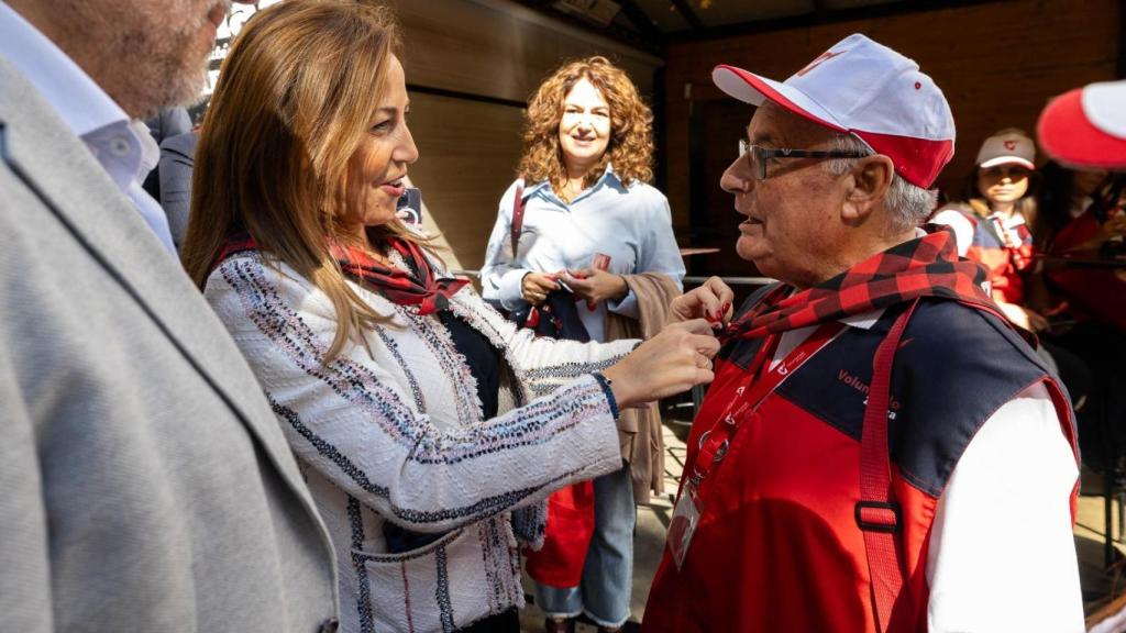La Alcaldesa de Zaragoza, Natalia Chueca, colocándole el cachirulo a uno de los voluntarios este jueves.