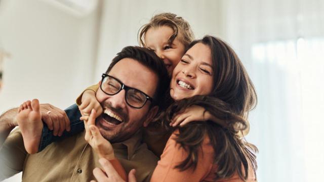 Niña alegre con sus tíos en casa.