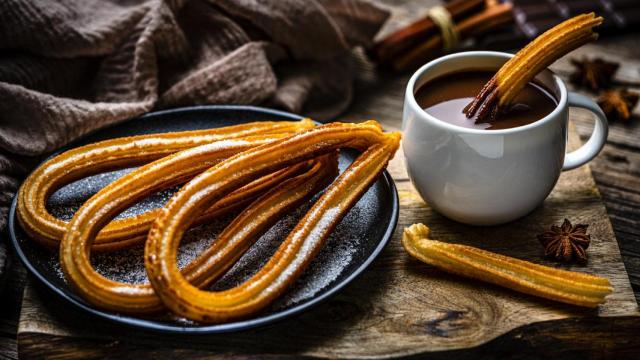 Una taza de chocolate con churros.