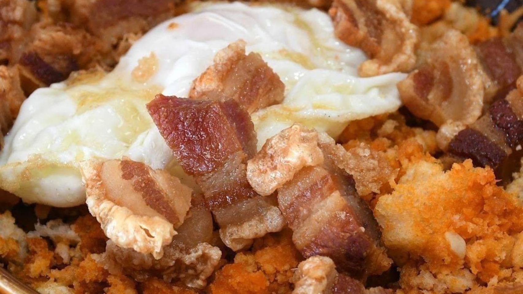 Migas con torrezno y huevo frito.