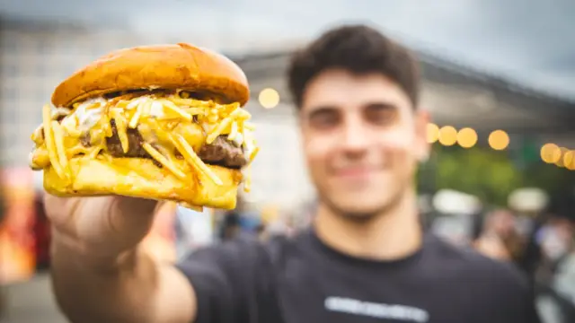 Un participante muestra una de las hamburguesas presentadas a concurso.