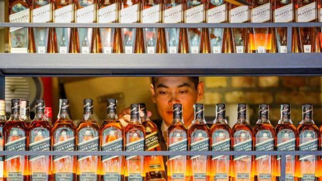 Un camarero coge una botella de Johnnie Walker, una de las marcas de Diageo.