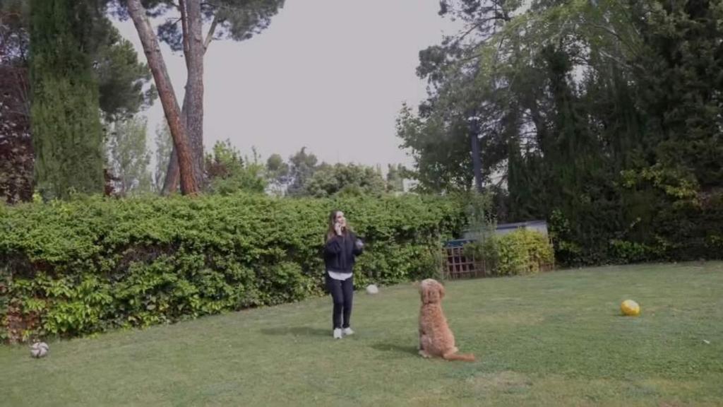 Malú jugando con su perro en el jardín de su casa.