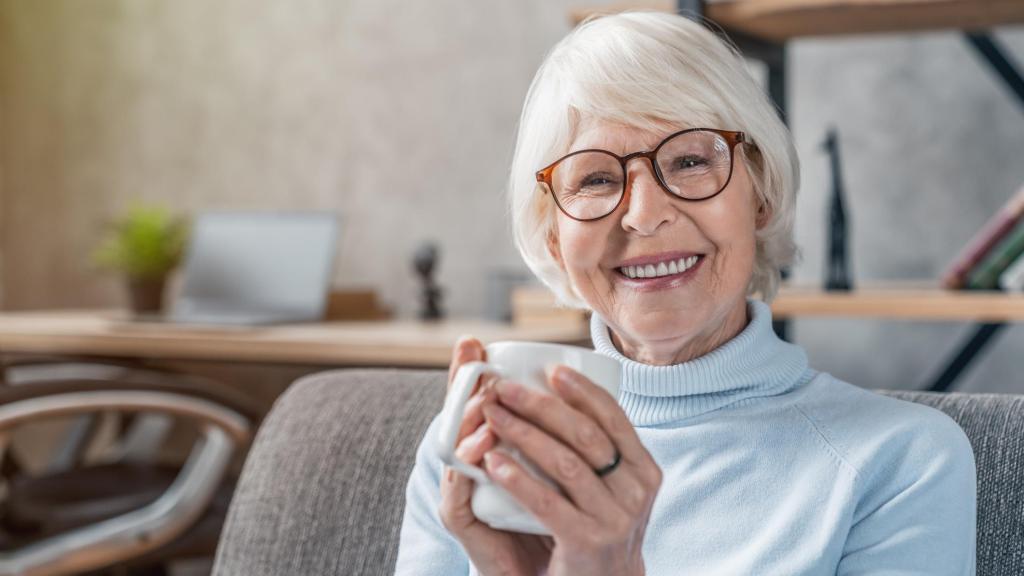 Una mujer mayor bebiendo café.