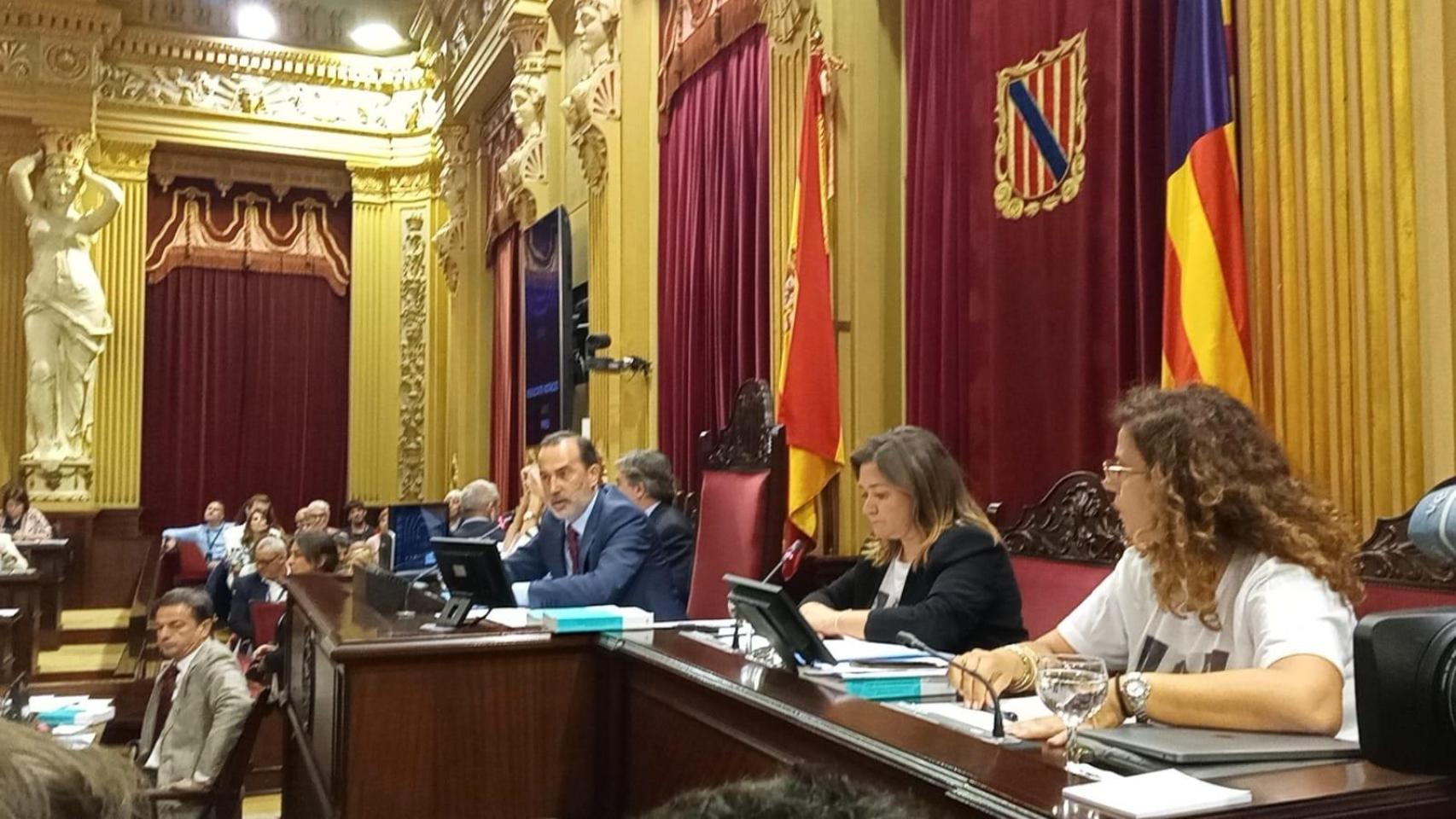 A la derecha las dos diputadas del PSOE con fotos de víctimas del franquismo durante el pleno en el Parlament balear.