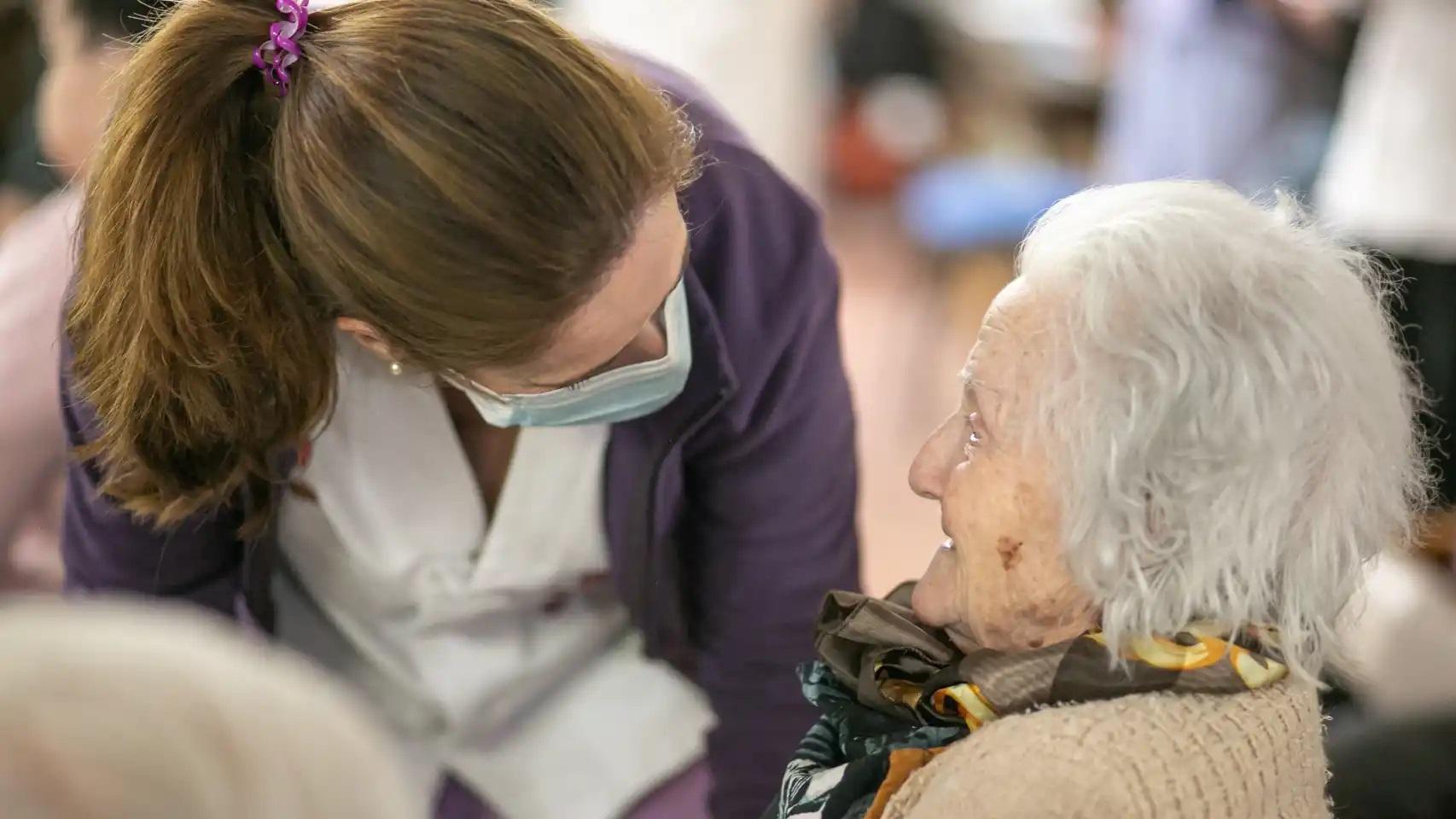 Una profesional atiende a una usuaria de una residencia para la Tercera Edad.