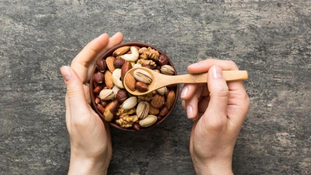 Mujer comiendo frutos secos.