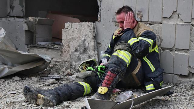 Un bombero cansado se sienta cerca de la clínica infantil Okhmatdit, atacada en julio.