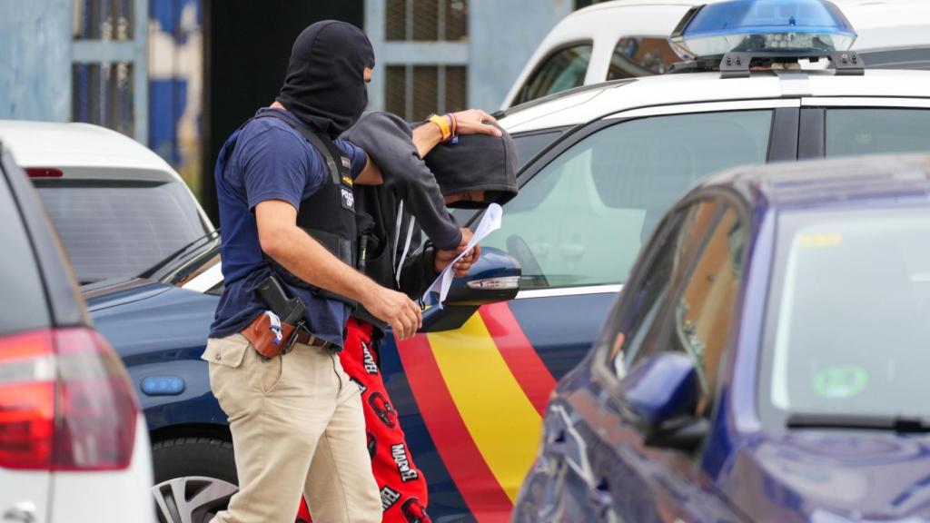 La Policía Nacional acompaña a uno de los detenidos.