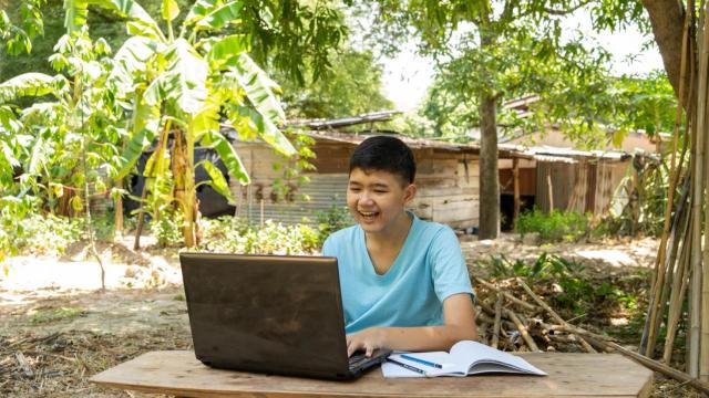 Un niño se divierte estudiando en línea con un ordenador portátil.