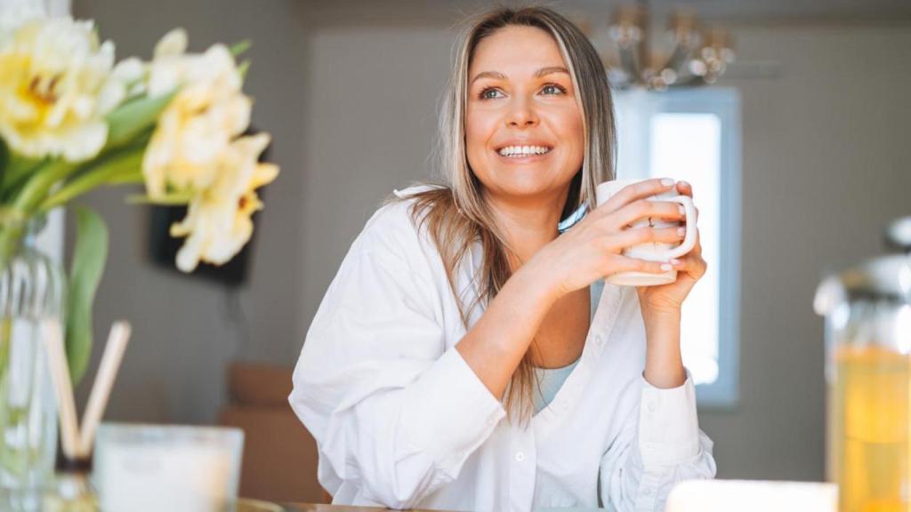 Mujer desayunando en su cocina.