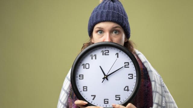 Una joven sujeta con las dos manos un reloj