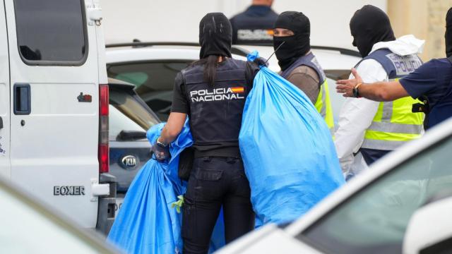 Agentes de policía trasladan bolsas de marihuana en una de las macrorredadas de las Tres Mil Viviendas.