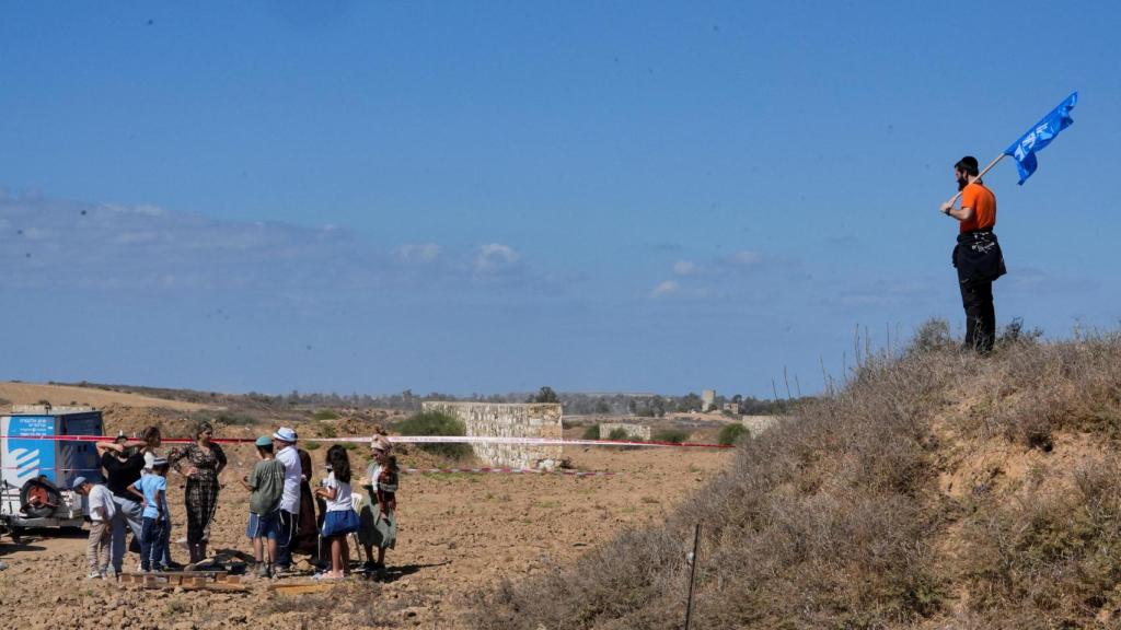 Un colono sostiene una bandera, el día de una conferencia sobre el reasentamiento de la Franja de Gaza, en Be'eri, sur de Israel.