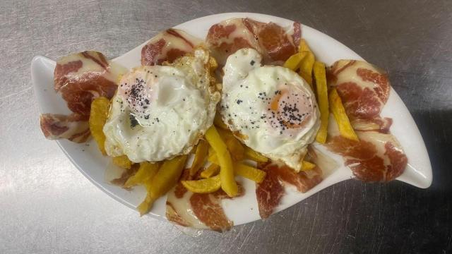 Huevos con patatas fritas caseras, jamón ibérico y sal negra.