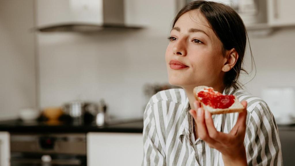 Mujer en la cocina con una tostada.