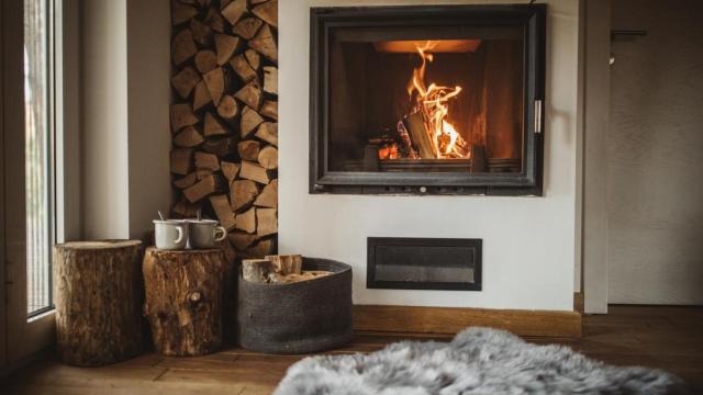 Una chimenea con cristal encendida.