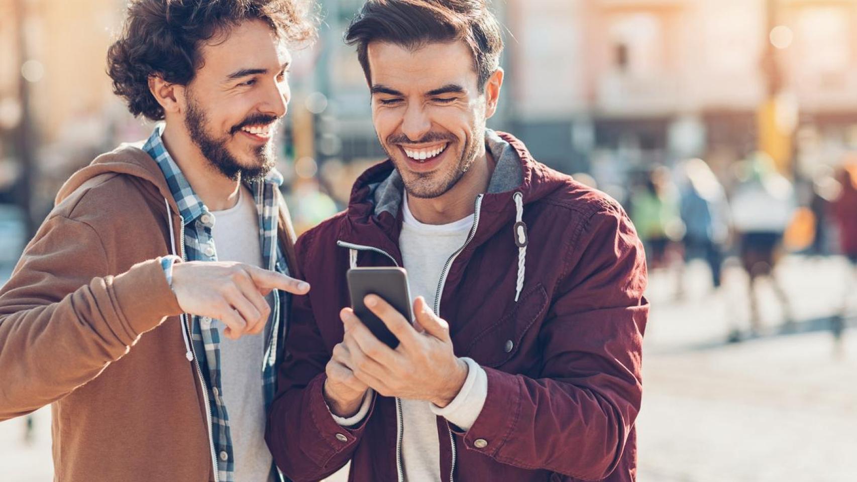 Dos jóvenes hablando y divirtiéndose en la calle.