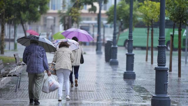 Imagen de personas caminando bajo la lluvia