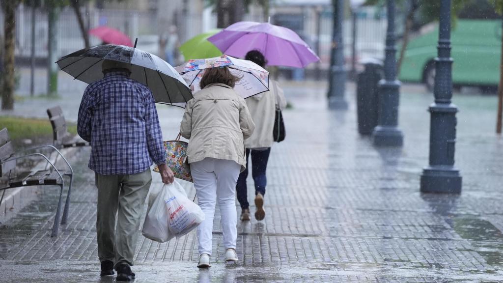 Imagen de personas caminando bajo la lluvia