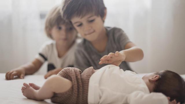 Dos niños observan a su hermano, imagen libre de derechos. Freepik