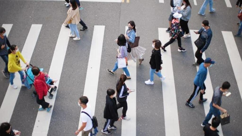 Personas caminando con mascarillas