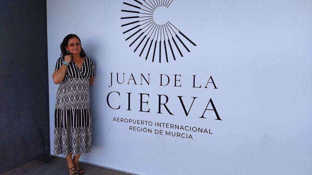 Ana de la Cierva, nieta del ingeniero Juan de la Cierva, inventor del autogiro,  en julio de 2022, posando en la fachada del aeropuerto que luce el nombre que ha anulado el TSJ.