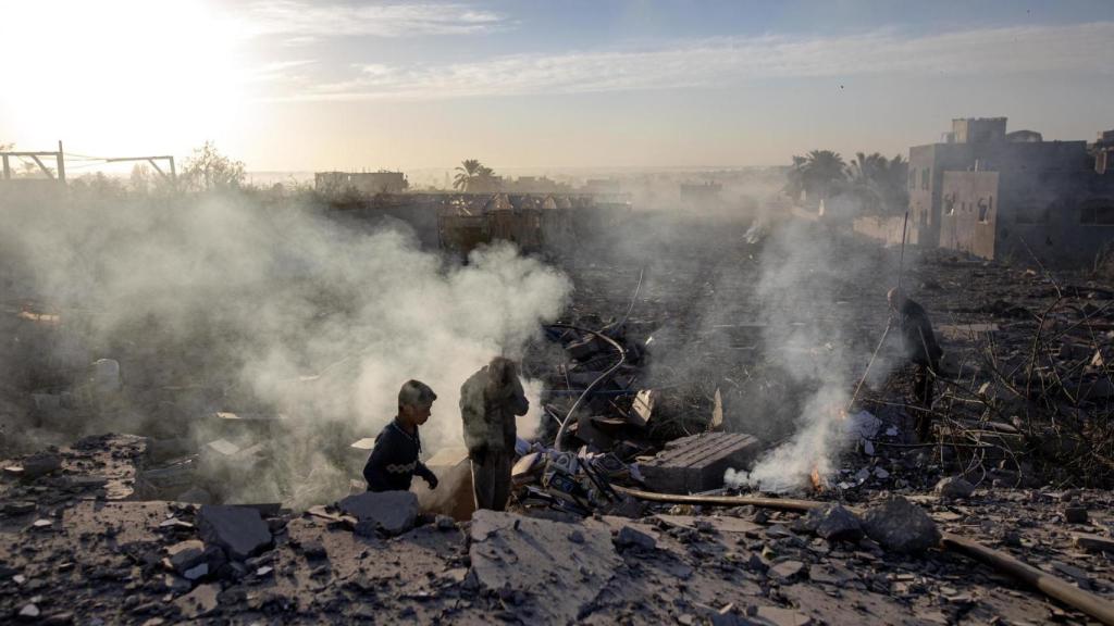 - Palestinos inspeccionan los restos de edificios destruidos tras los ataques aéreos israelíes en Jan Yunis, sur de la Franja de Gaza