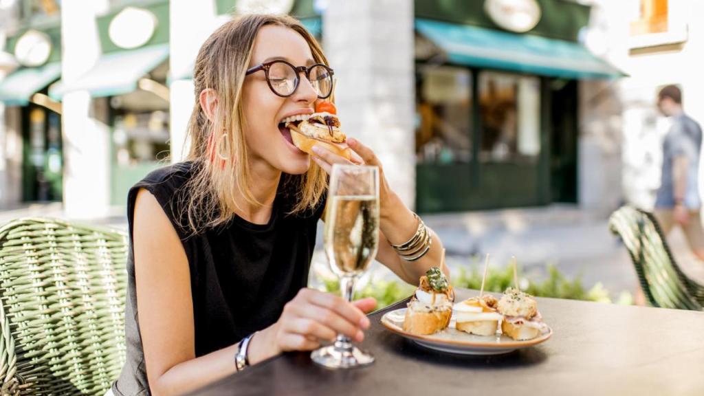 Mujer comiendo pinchos y tapas típicas.