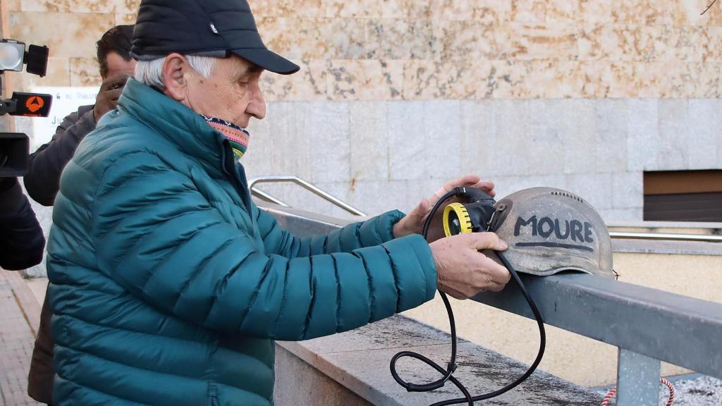 Manuel coloca un casco de mineor en homenaje a su hijo fallecido