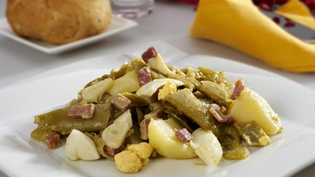 Un plato de judías con patatas y huevo