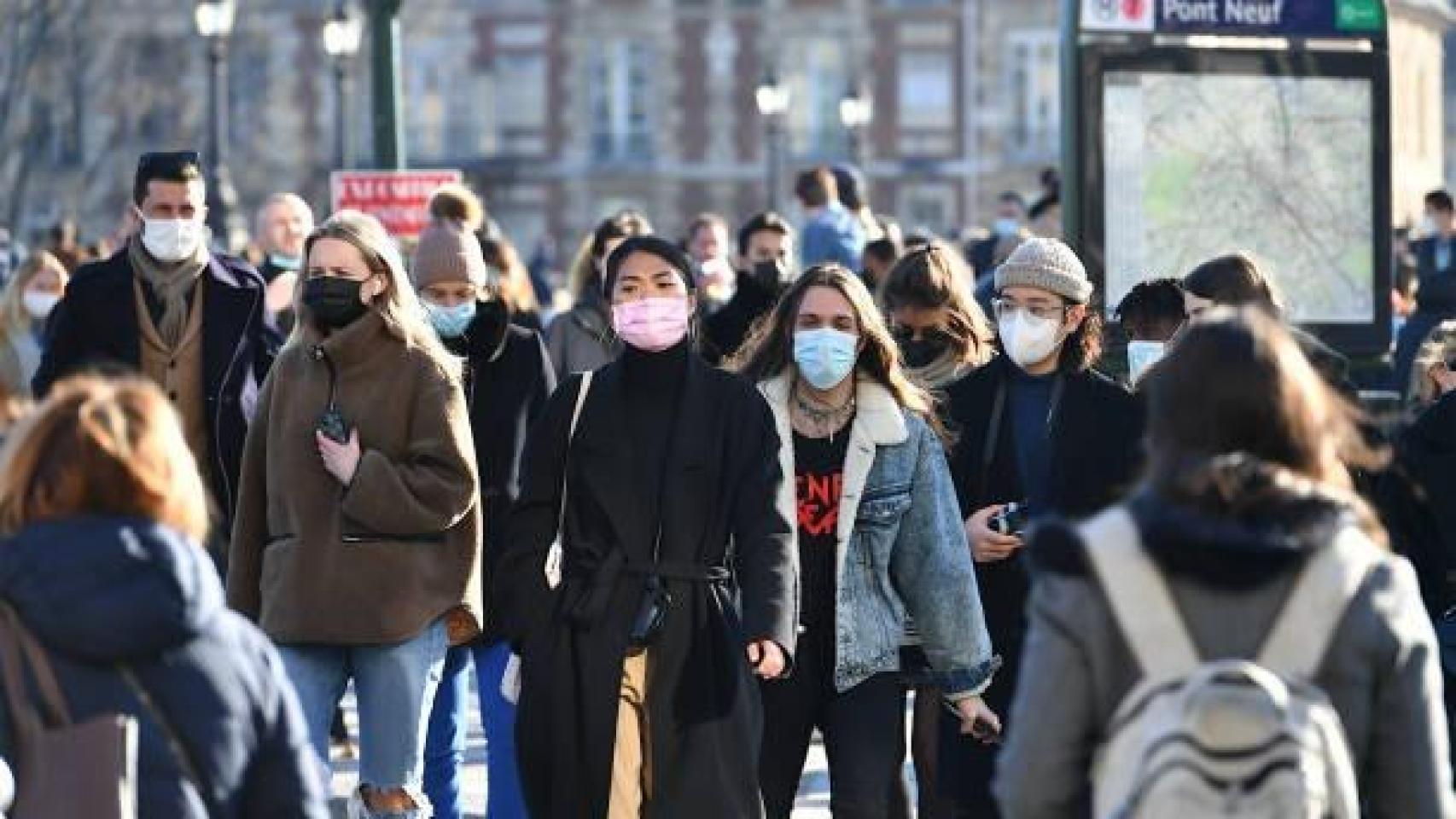 Personas caminando con mascarillas