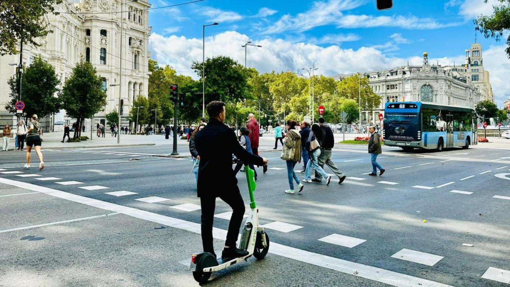 Un usuario en un patinete eléctrico de alquiler, a la altura de Cibeles, en Madrid.