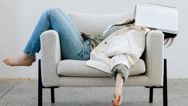 Mujer cansada con libreta en la cara