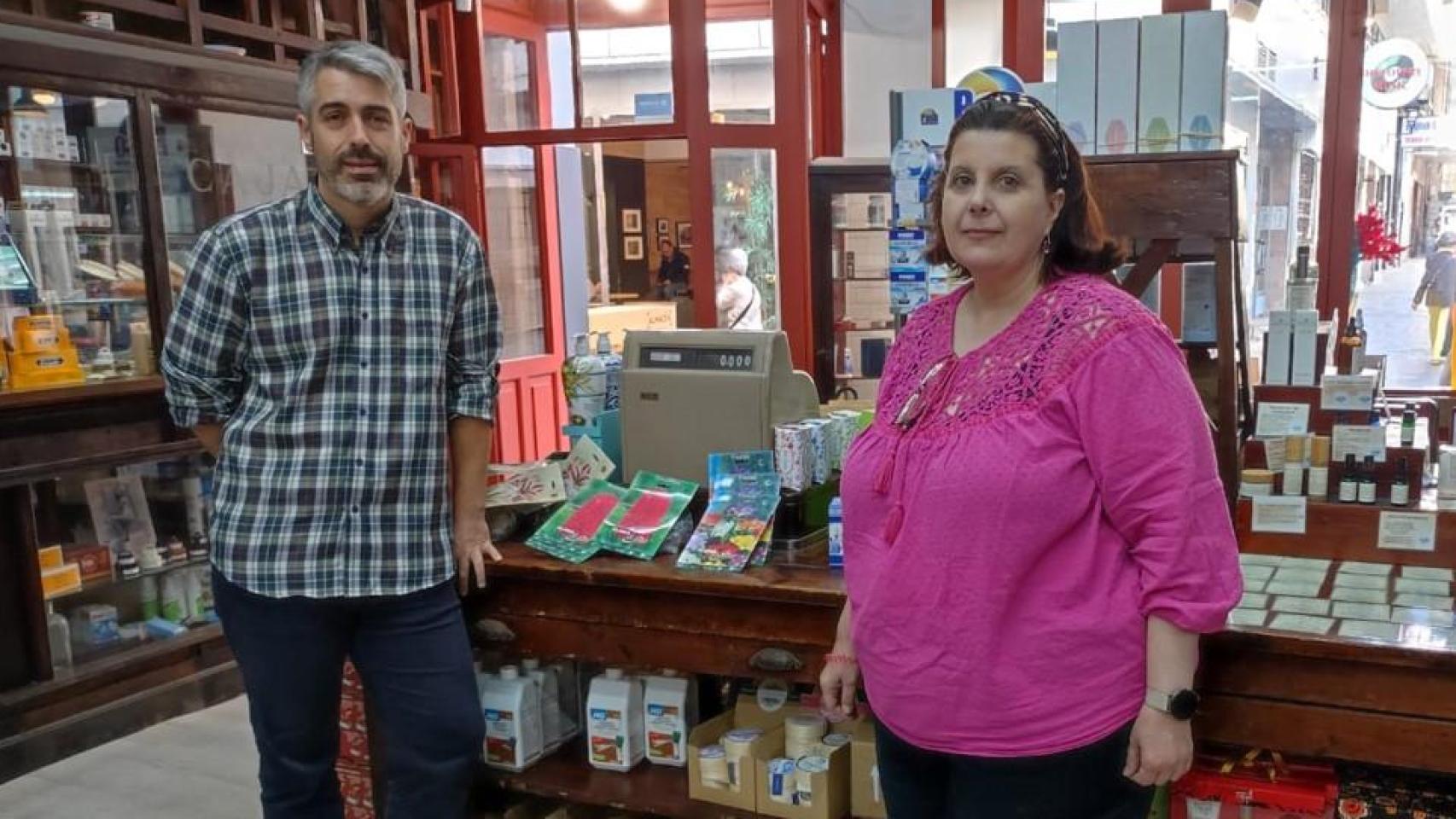 Jorge González y Elena González, en el interior de la droguería Villar, junto a una báscula comprada en 1921.