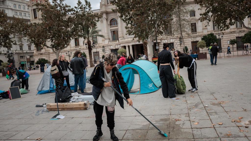 Participantes en la acampada por la vivienda instalada en la plaza del Ayuntamiento de Valencia recogen sus tiendas de campaña tras acordar desconvocarla. Efe / Biel Aliño