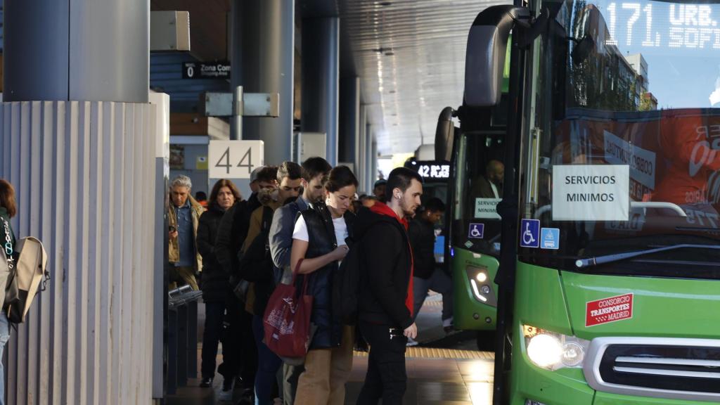 Varios usuarios del transporte público en un intercambiador de autobuses en Madrid.