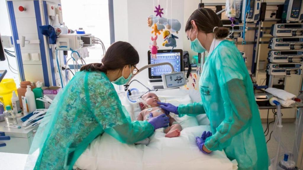 Dos enfermeras cuidando de un bebé en la UCI pediátrica del Hospital Sant Joan de Dèu de Barcelona.