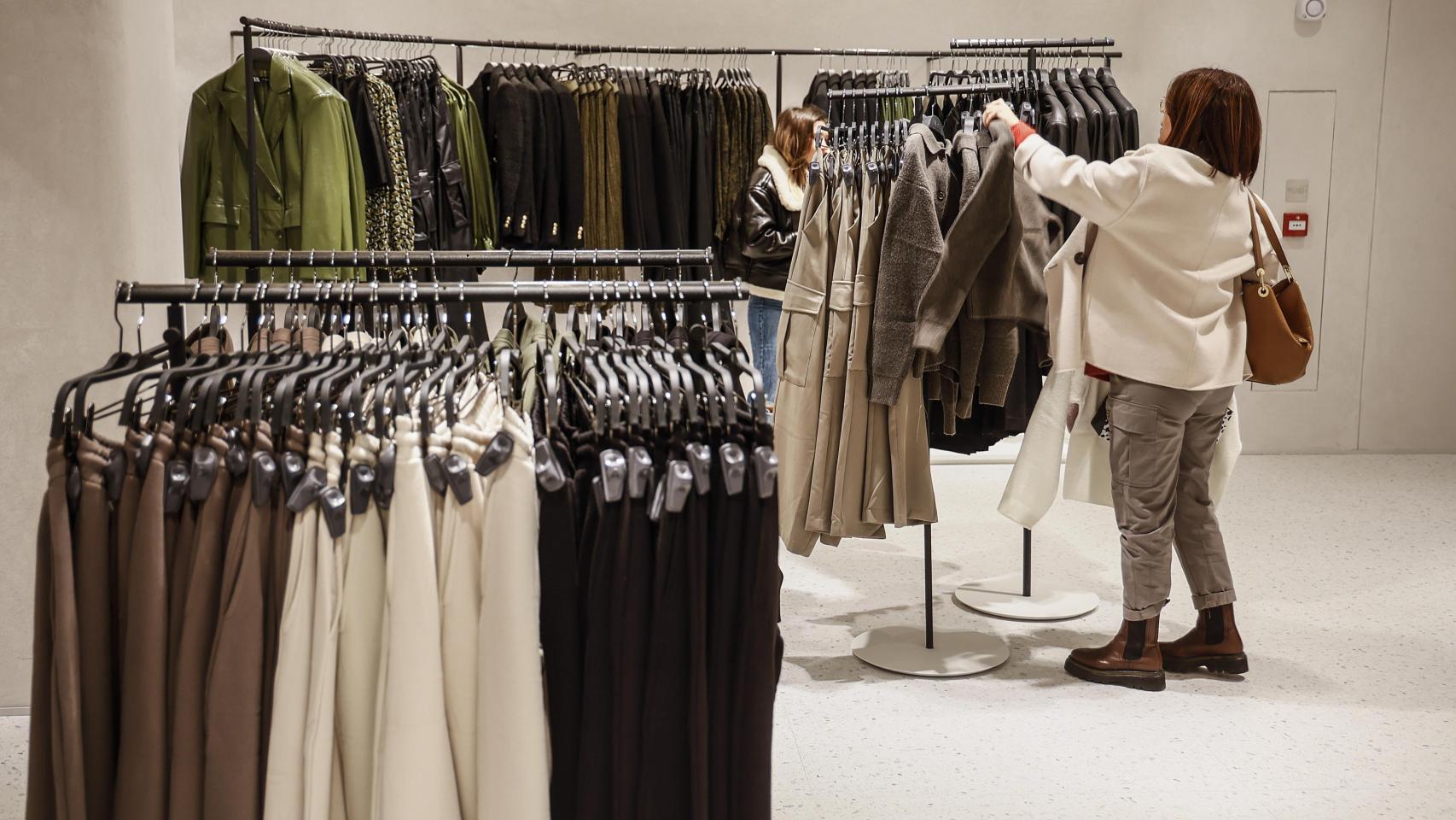 Una mujer mira prendas de ropa en una tienda de Inditex en España.