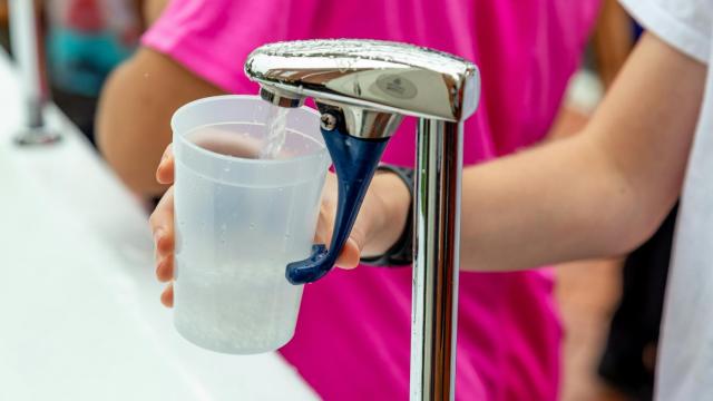 Una persona sirviéndose un vaso de agua.